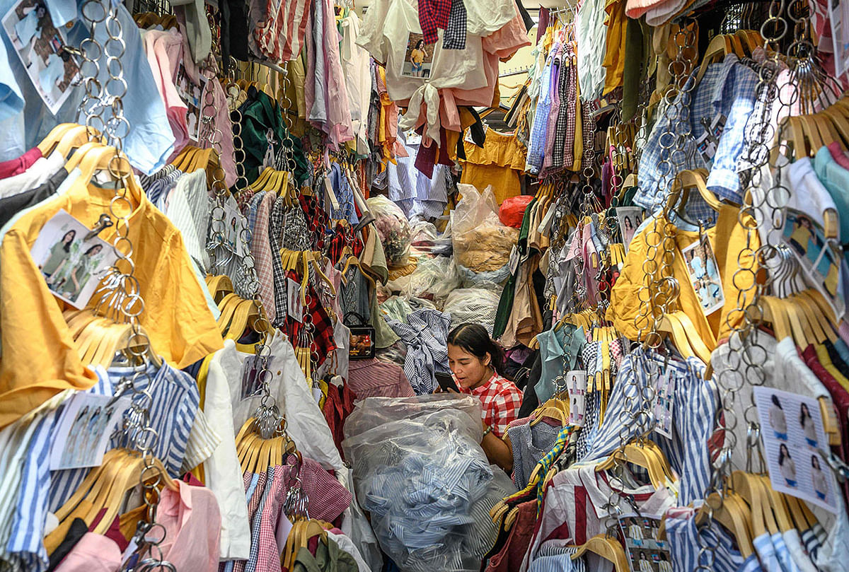 A clothes vendor talks on the phone in her boot at Pratunam market in Bangkok on 9 December 2019. Photo: AFP