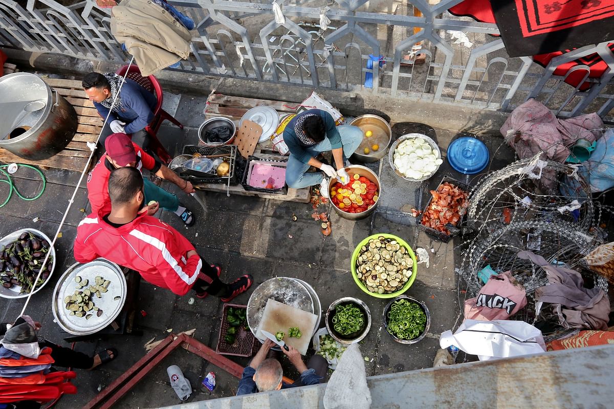 Iraqis prepare food on the sidelines of ongoing anti-government protests at Tahrir square in the capital Baghdad amid on 10 December 2019. Photo: AFP
