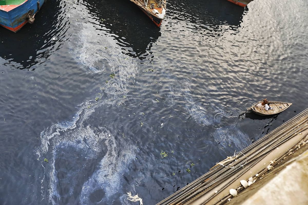 People ride a boat in the water of river Buriganga that gets polluted by sewerage waste at Babubazar, Dhaka on 9 December 2019. Photo: Dipu Malakar