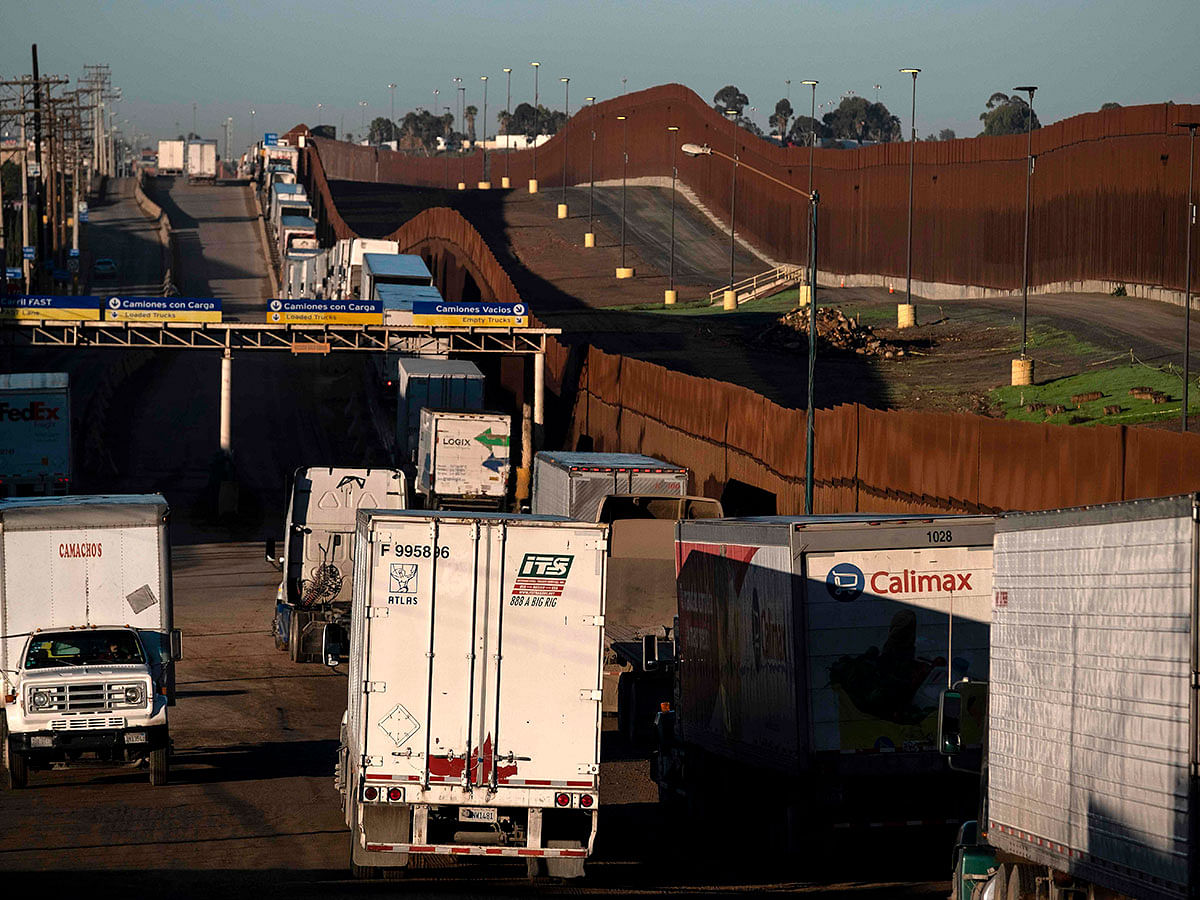 Trucks line up near the border fence to cross to the United States at Otay Commercial port of entry in Tijuana, Baja California state, Mexico, on 10 December 2019. Officials from the US, Canada and Mexico will meet in Mexico on Tuesday for talks on a new continent-wide trade deal after US president Donald Trump hinted that efforts to push the pact through the US Congress were close to success. Photo: AFP