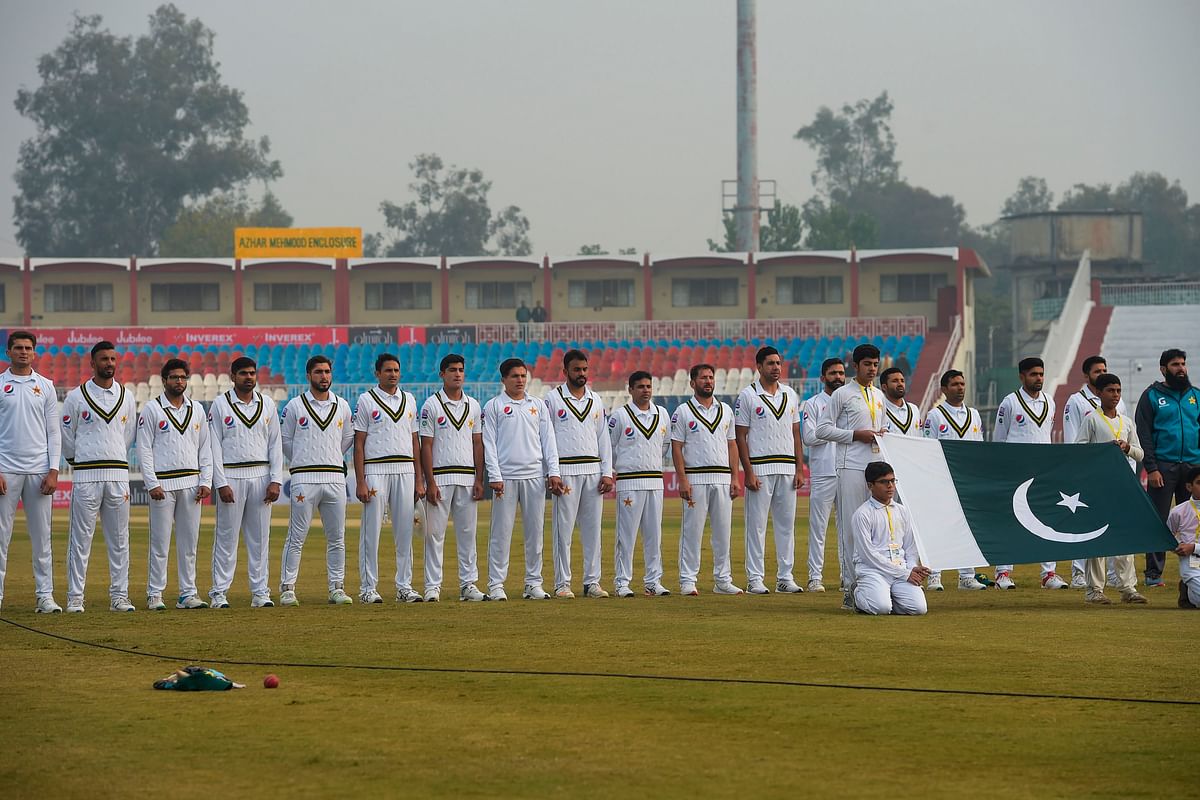 Pakistan`s cricket team members listen to national anthem before the start of the first day of the first Test cricket match between Pakistan and Sri Lanka at the Pindi Cricket Stadium in Rawalpindi on 11 December 2019. Photo: AFP