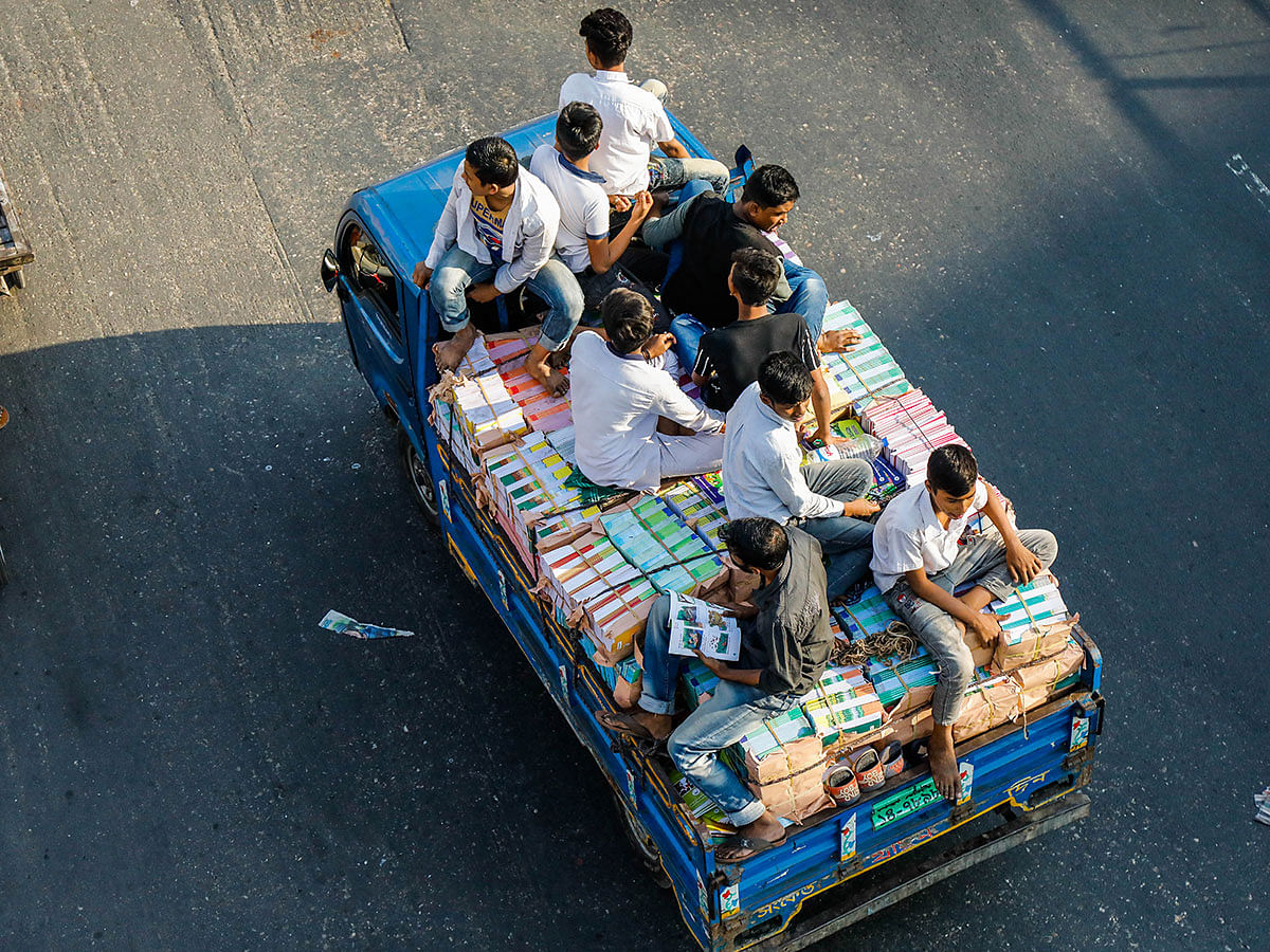 A pickup loaded with new textbooks and workers ply along a road at Jatrabari, Dhaka on 10 December 2019. The books are delivered to primary and secondary schools ahead of the book distribution festival to be observed on the New Year`s Day across the country. Photo: Dipu Malakar
