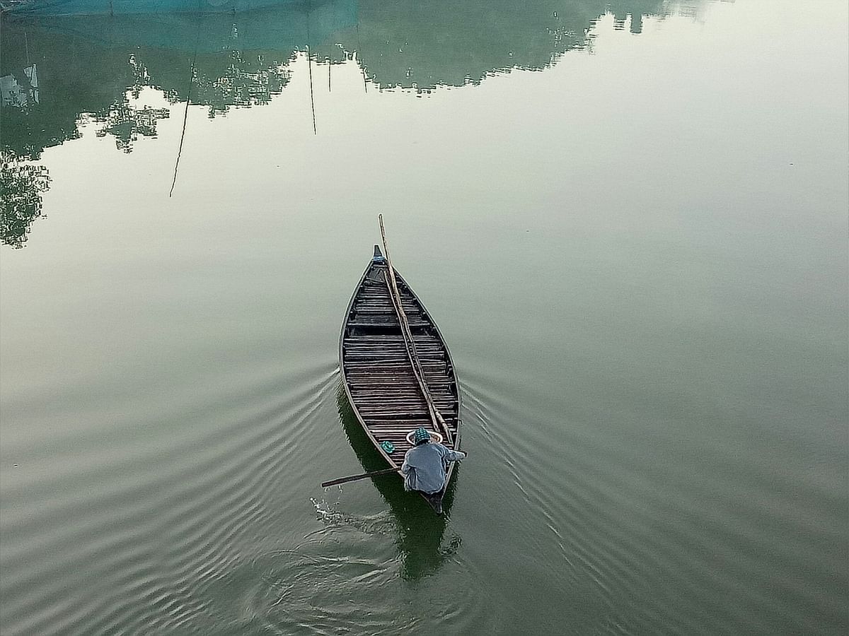 A fisherman rows a boat in the Kumar River at Bakhuda, Faridpur on 8 December. Photo: Alimuzzaman