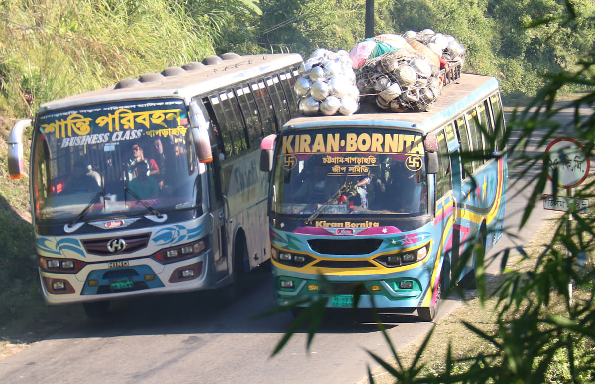 Two buses race side by side along a narrow, zigzag hilly road at Shilachhara, Khagrachhari on 9 December 2019. Photo: Nerob Chowdhury