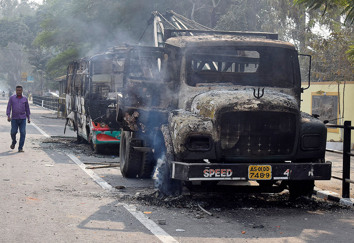 A man walks past damaged vehicles that were set on fire by demonstrators, during a protest after India`s parliament passed Citizenship Amendment Bill, in Guwahati, India on 12 December 2019. Photo: Reuters