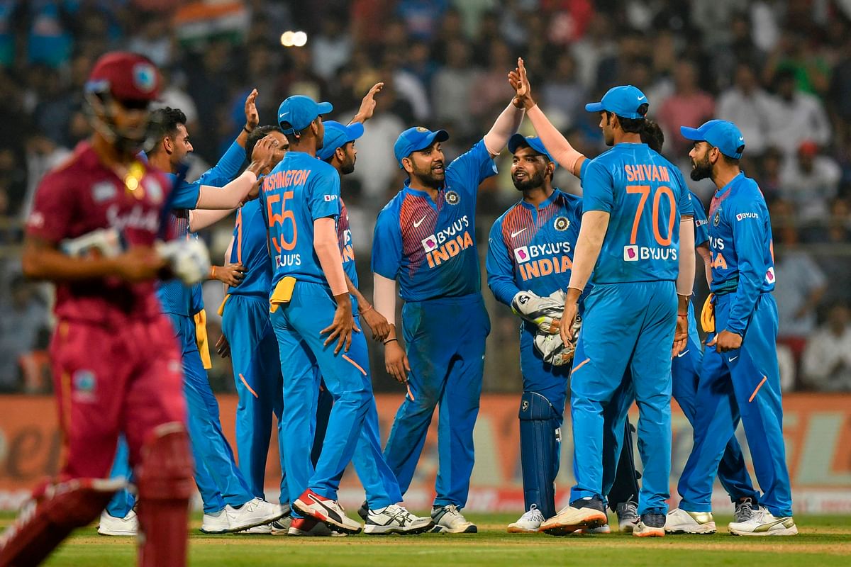 India`s cricketers celebrate during the third T20 international cricket match of a three-match series between India and West Indies at the Wankhede Stadium in Mumbai on 11 December 2019. Photo: AFP