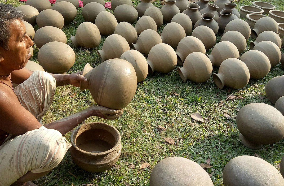 A potter works on a pottery in the sun at Pasra, Faridpur on 11 December 2019. Potteries are in demand during winter for collecting date juice. Photo: Alimuzzaman