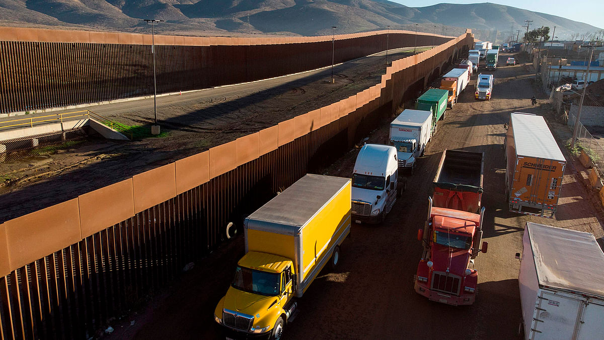 Aerial view of trucks lining up near the border fence to cross to the United States at Otay Commercial port of entry in Tijuana, Baja California state, Mexico, on 10 December 2019. Photo: AFP