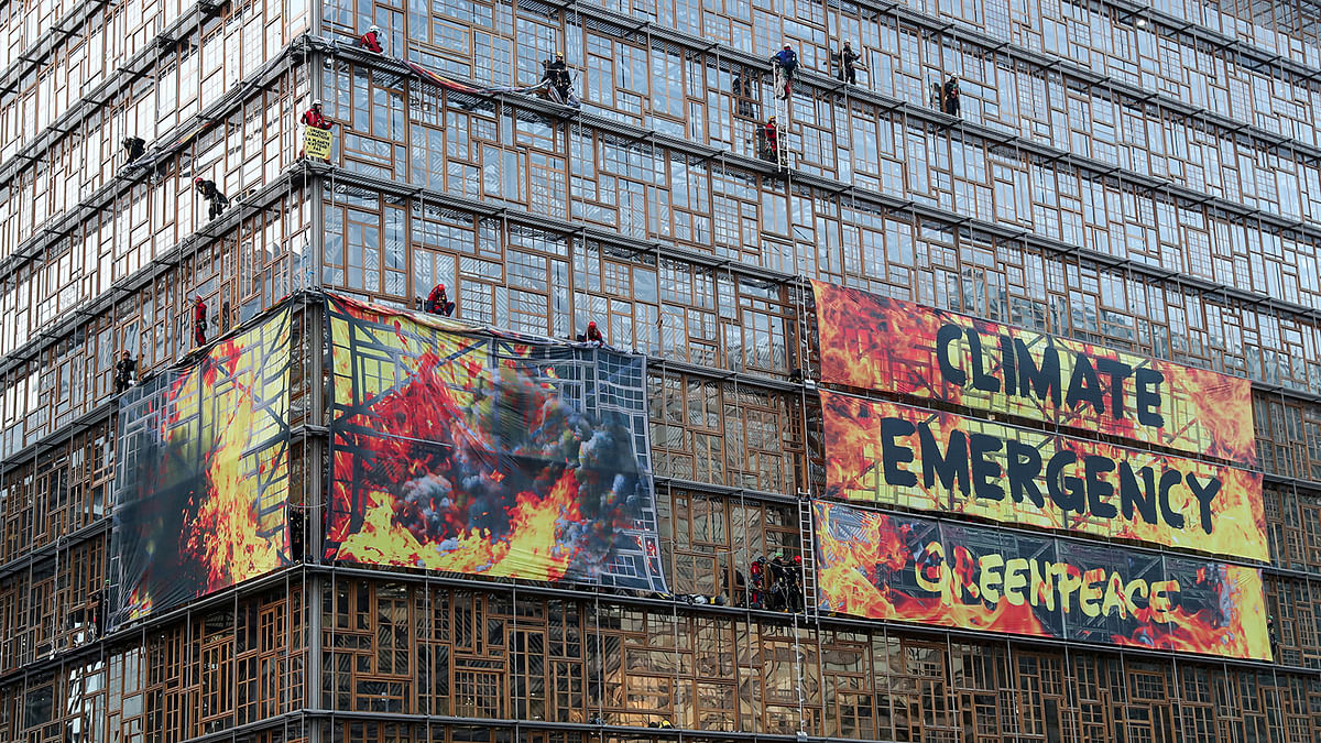 Climate change activists from Greenpeace display banners outside the EU Council headquarters, depicting the building on fire, ahead of an EU leaders summit in Brussels, Belgium on 12 December 2019. Photo: Reuters