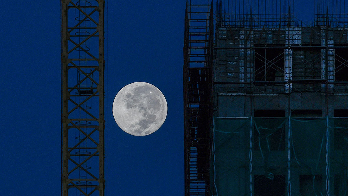 The moon is seen near a construction site in Kuala Lumpur on 13 December 2019. Photo: AFP