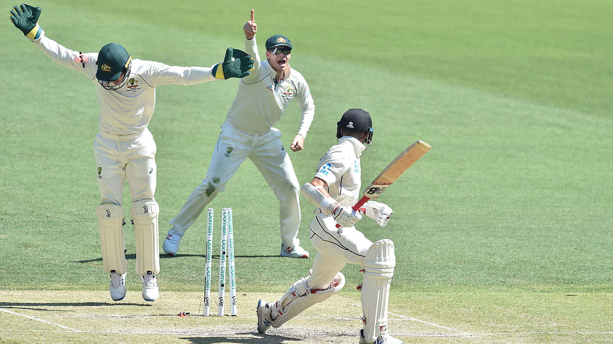 New Zealand`s Mitchell Santner (R) is bowled out by Australia`s Marnus Labuschagne on day three of the first Test cricket match at the Perth Stadium in Perth on 14 December 2019. Photo: AFP
