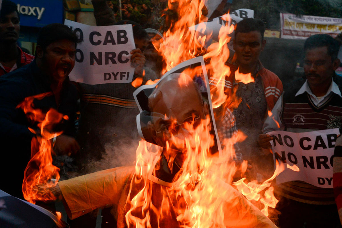 Indian left wing activists of Democratic Youth Federation of India (DYFI) shout slogans as they burn an effigy of India`s Home Minister Amit Shah during a demonstration against the Indian government`s Citizenship Amendment Bill in Siliguri on Saturday. Photo: AFP
