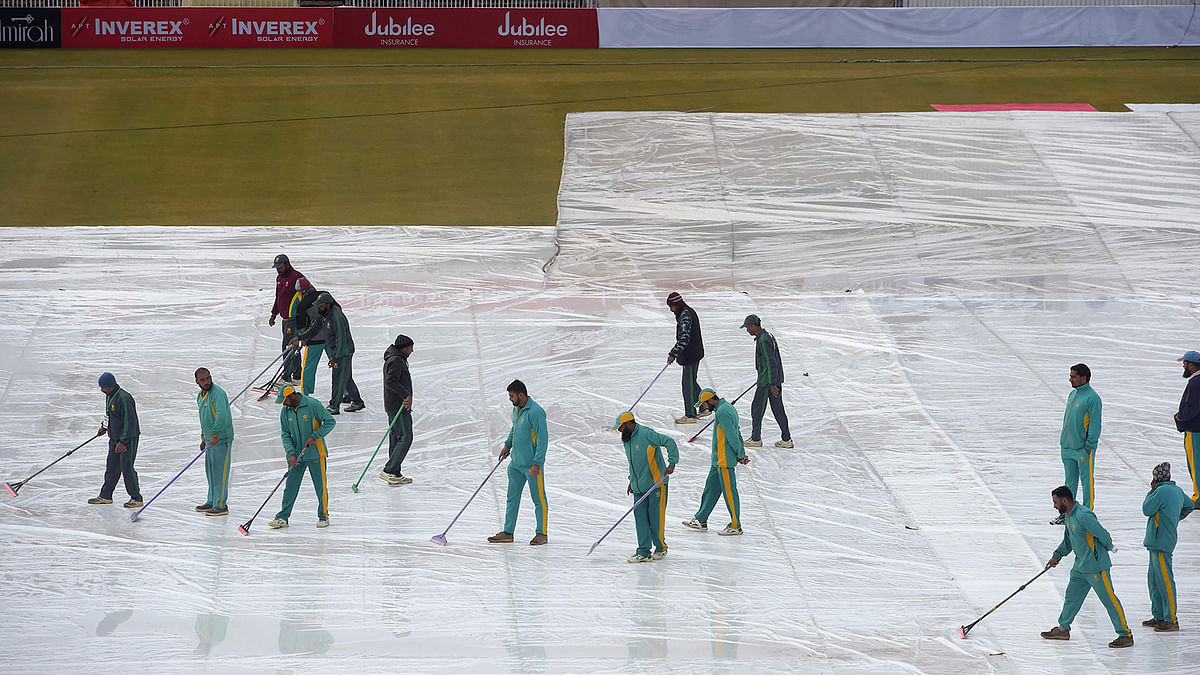 Ground staff remove rain water from the pitch during the fourth day of the first Test cricket match between Pakistan and Sri Lanka at the Rawalpindi Cricket Stadium in Rawalpindi on 14 December 2019. Photo: AFP