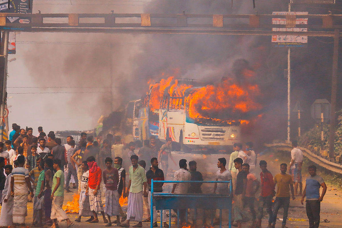 Protesters block a road after setting buses on fire during a demonstration against the Indian government`s Citizenship Amendment Bill (CAB) in Howrah, on the outskirts of Kolkata on 14 December 2019. Photo: AFP