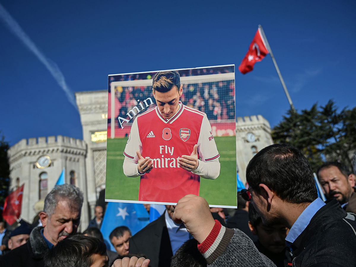 A supporter of China`s Muslim Uighur minority holds a placard of Arsenal`s Turkish origin German midfielder Mesut Ozil during a demonstration at Beyazid square in Istanbul on Saturday. Photo: AFP