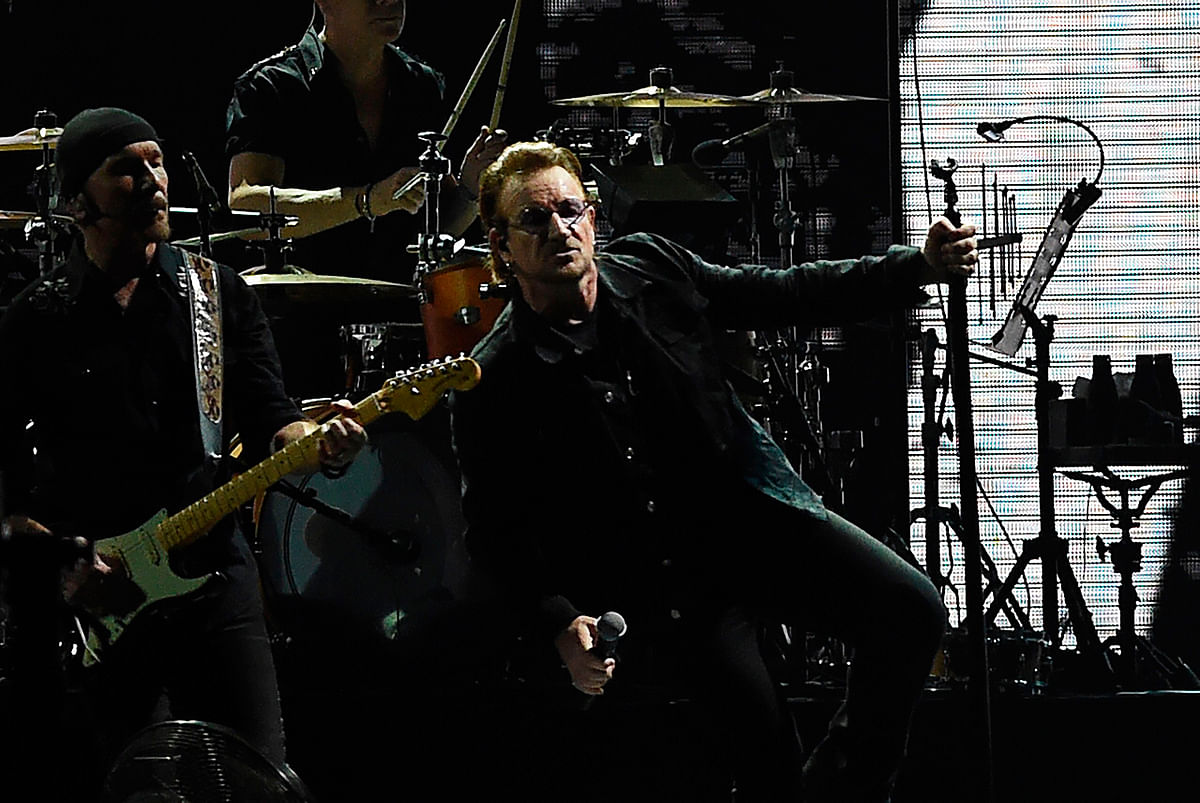 Irish rock band U2 singer Bono (R) performs during a concert at the D.Y. Patil stadium in Navi Mumbai on 15 December, 2019. Photo: AFP