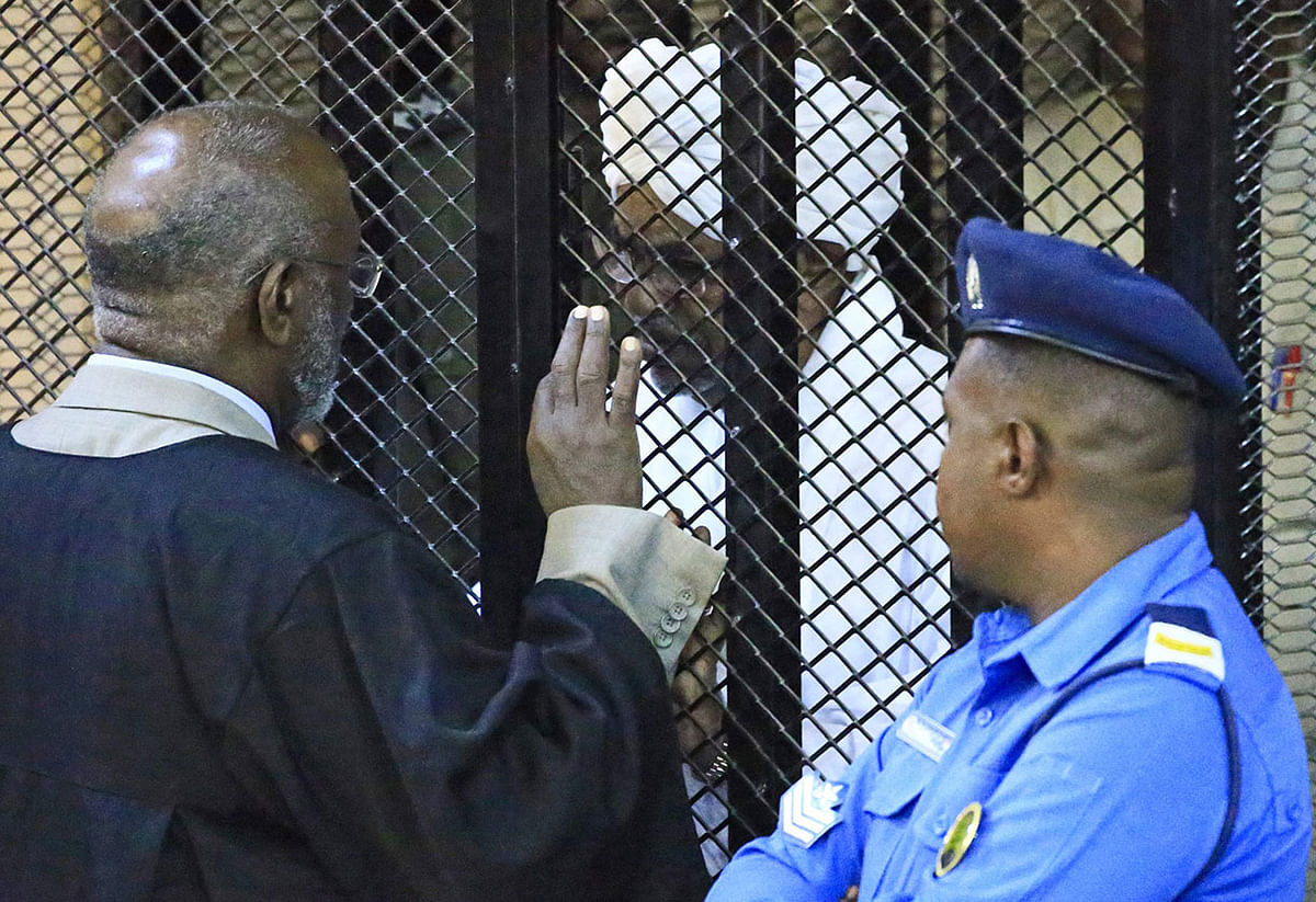 Sudan`s deposed military president Omar al-Bashir sits in a defendant`s cage during his corruption trial at a court in Khartoum on 14 December 2019. Photo: AFP