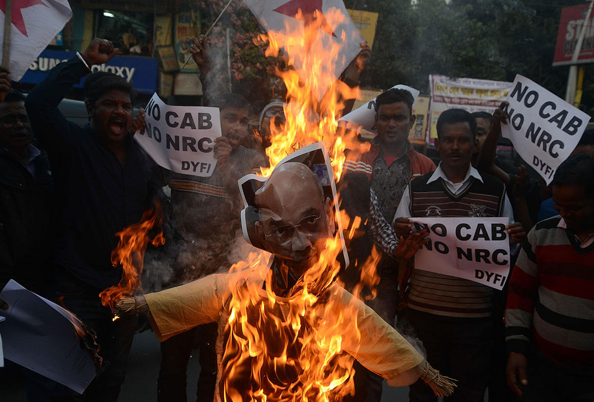 Indian left wing activists of Democratic Youth Federation of India (DYFI) shout slogans as they burn an effigy of India`s home minister Amit Shah during a demonstration against the Indian government`s Citizenship Amendment Bill in Siliguri on 14 December 2019. Photo: AFP