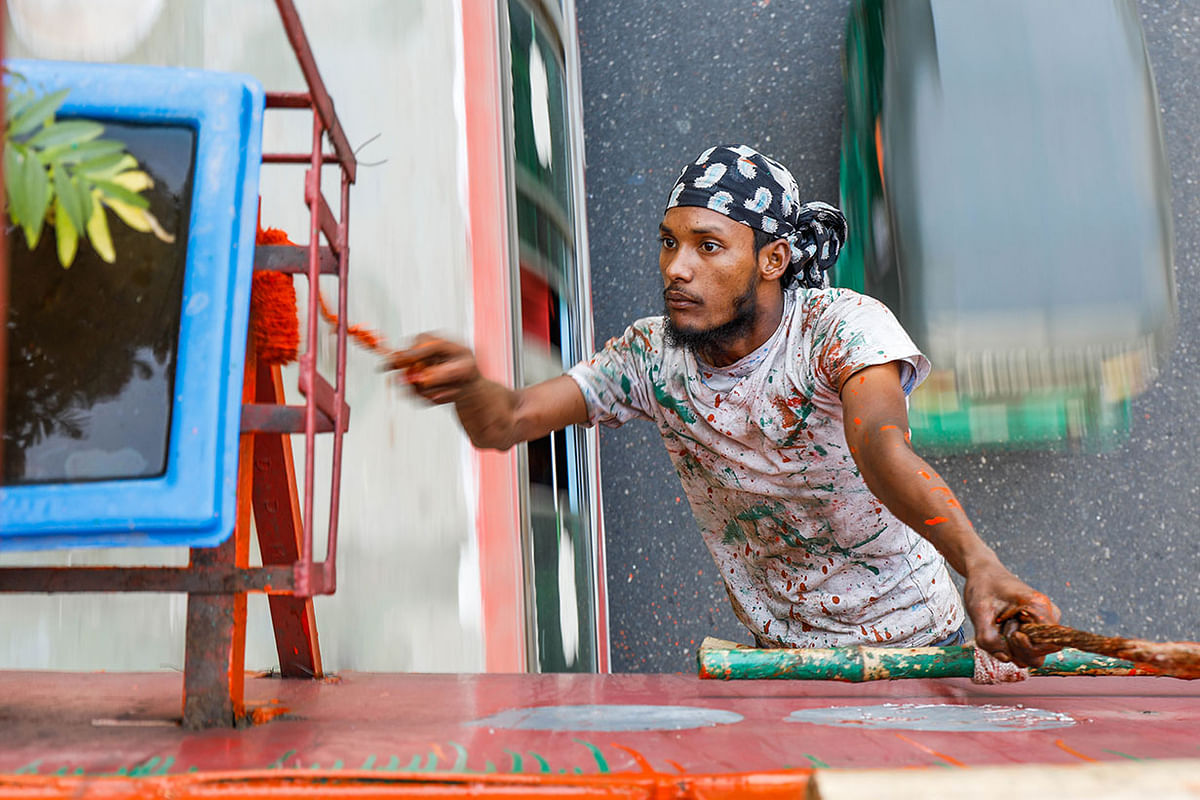 A worker paints an over bridge without any safety arrangements on the eve of the Victory Day at Banani, Dhaka on 15 December 2019. Photo: Dipu Malakar