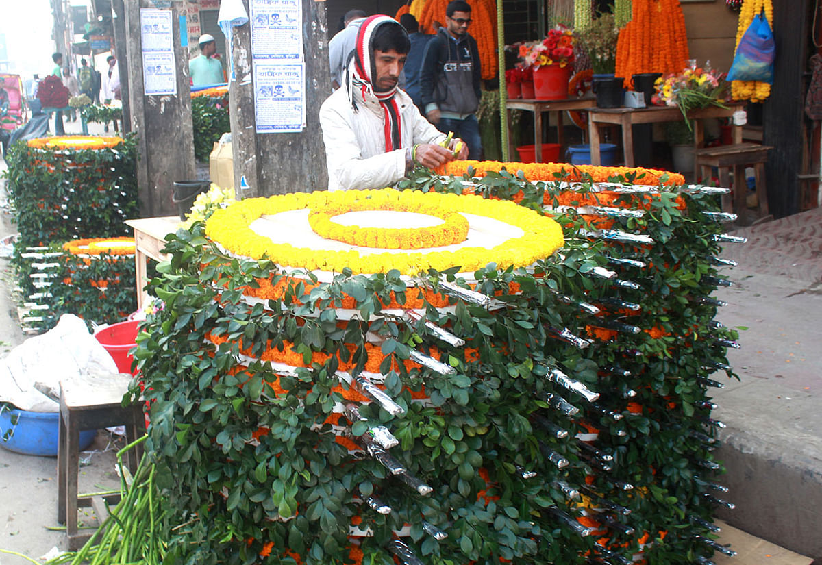 A man sorts wreaths ahead of the Victory Day at Mymensingh on 15 December 2019. Photo: Anwar Hossain