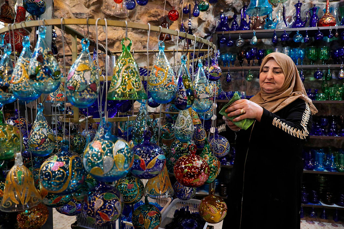 IndonesiaA Palestinian woman dusts glass Christmas ornaments on display at a workshop in the southern West Bank city of Hebron, on 15 December. Photo: AFP