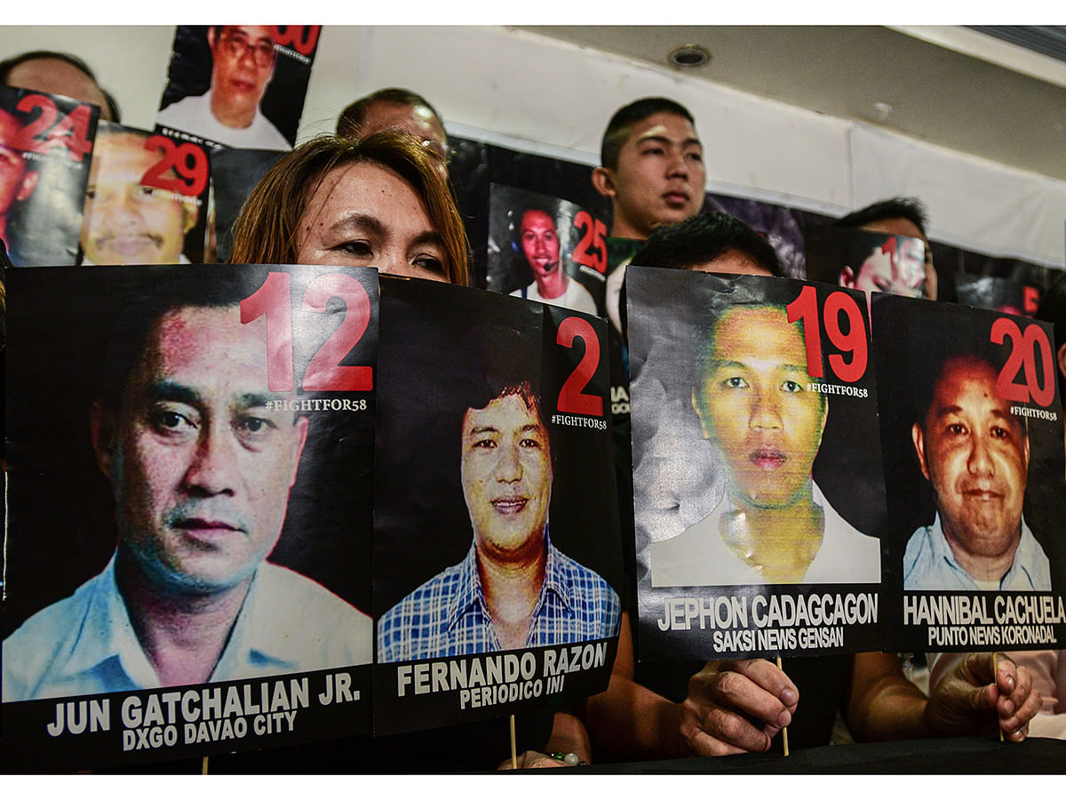Relatives and supporters of victims of the 2009 Maguindanao massacre hold pictures of the victims during a press conference after the verdict in the case in Taguig, Manila on Thursday. Photo: AFP