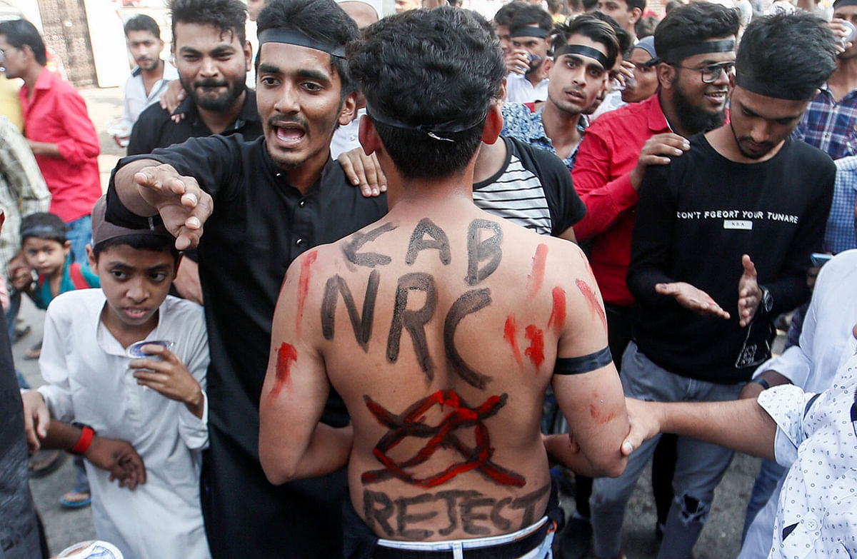 A man with a slogan painted on his back is seen during a protest against a new citizenship law, on the outskirts of Mumbai, India, on 18 December 2019. Photo: Reuters