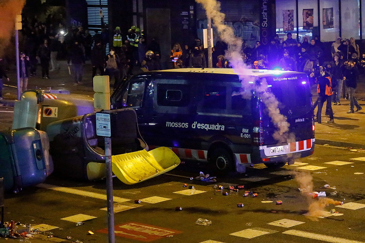 A van of the Catalan regional police `Mossos d`Esquadra` drives into a barricade made with garbage containers during a protest called by Catalan separatist movement Democratic Tsunami outside the Camp Nou stadium in Barcelona on 18 December 2019, during the `El Clasico` Spanish League football match. Photo: AFP