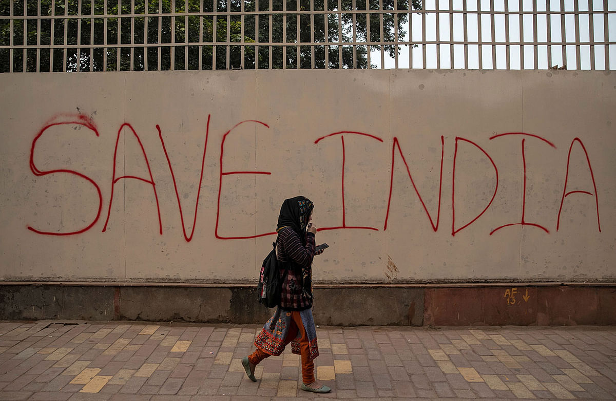 A demonstrator walks past a graffiti during a protest against a new citizenship law, outside the Jamia Millia Islamia university in New Delhi, India, on 18 December 2019. Photo: Reuters