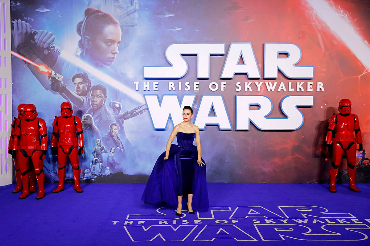 British actor Daisy Ridley poses with sith stormtroopers on the red carpet upon arrival for the European film premiere of Star Wars: The Rise of Skywalker in London on 18 December. Photo: AFP