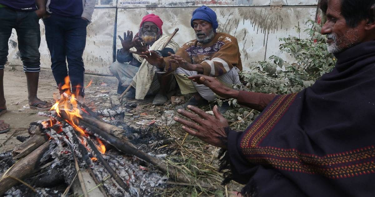 people warms them sitting around a bonfire as a cold wave sweeps over parts of Bangladesh. Photo: UNB