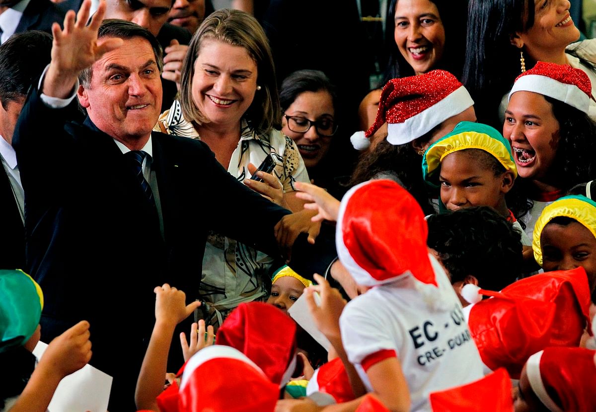 President Jair Bolsonaro greets schoolchildren during a Christmas event, at the Federal District public school in Brasilia on 19 December 2019. Photo: AFP