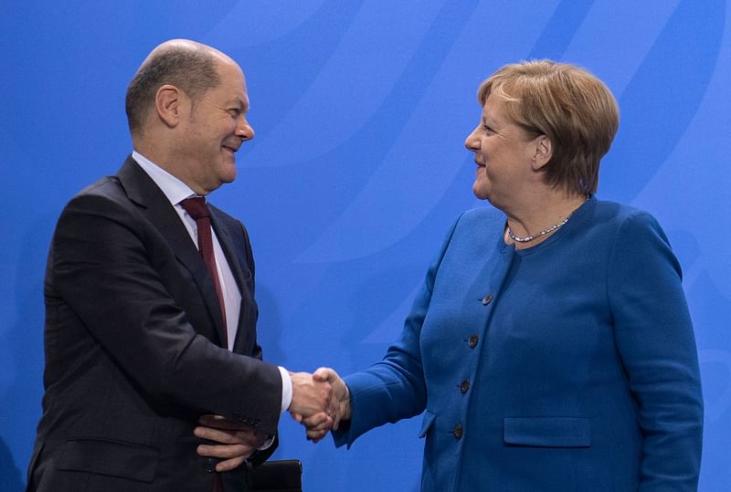 German chancellor Angela Merkel (R) and German finance minister and vice-chancellor Olaf Scholz (L) shake hands after a press conference following the signing of a declaration of intent to promote the recruitment of foreign skilled workers in Germany, by the Federal Government, representatives of industry and representatives of trade unions, on 16 December 2019 at the Chancellery in Berlin. Photo: AFP