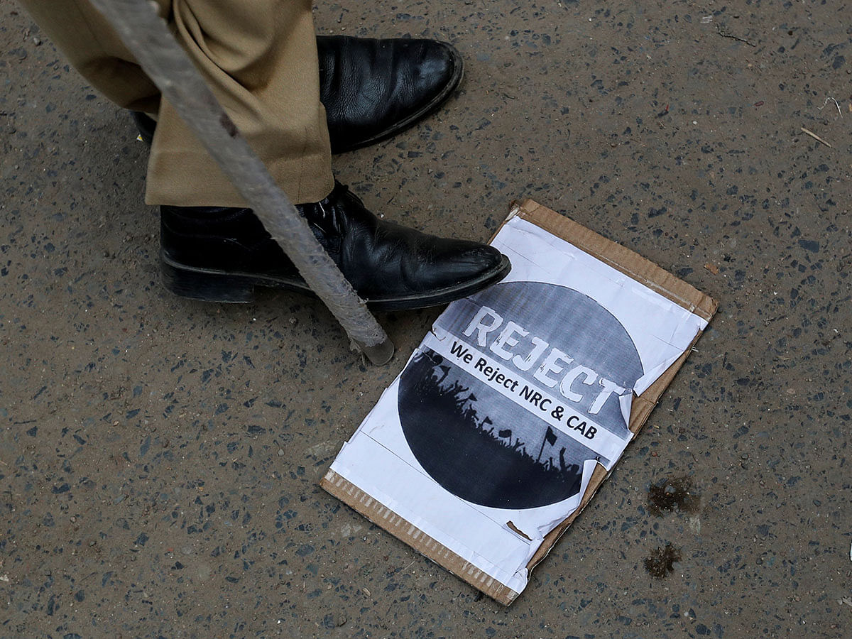 A police officer stands next to a placard as he keeps a watch during a protest against a new citizenship law, after Friday prayers at Jama Masjid in the old quarters of Delhi, India, on 20 December 2019. Photo: Reuters