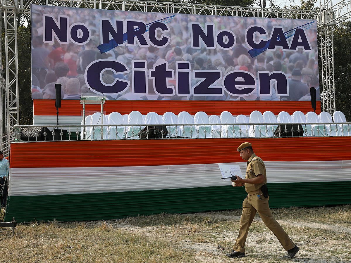 A policeman walks past a hoarding at the venue of a protest rally against a new citizenship law in Kolkata, India on 20 December 2019. Photo: Reuters