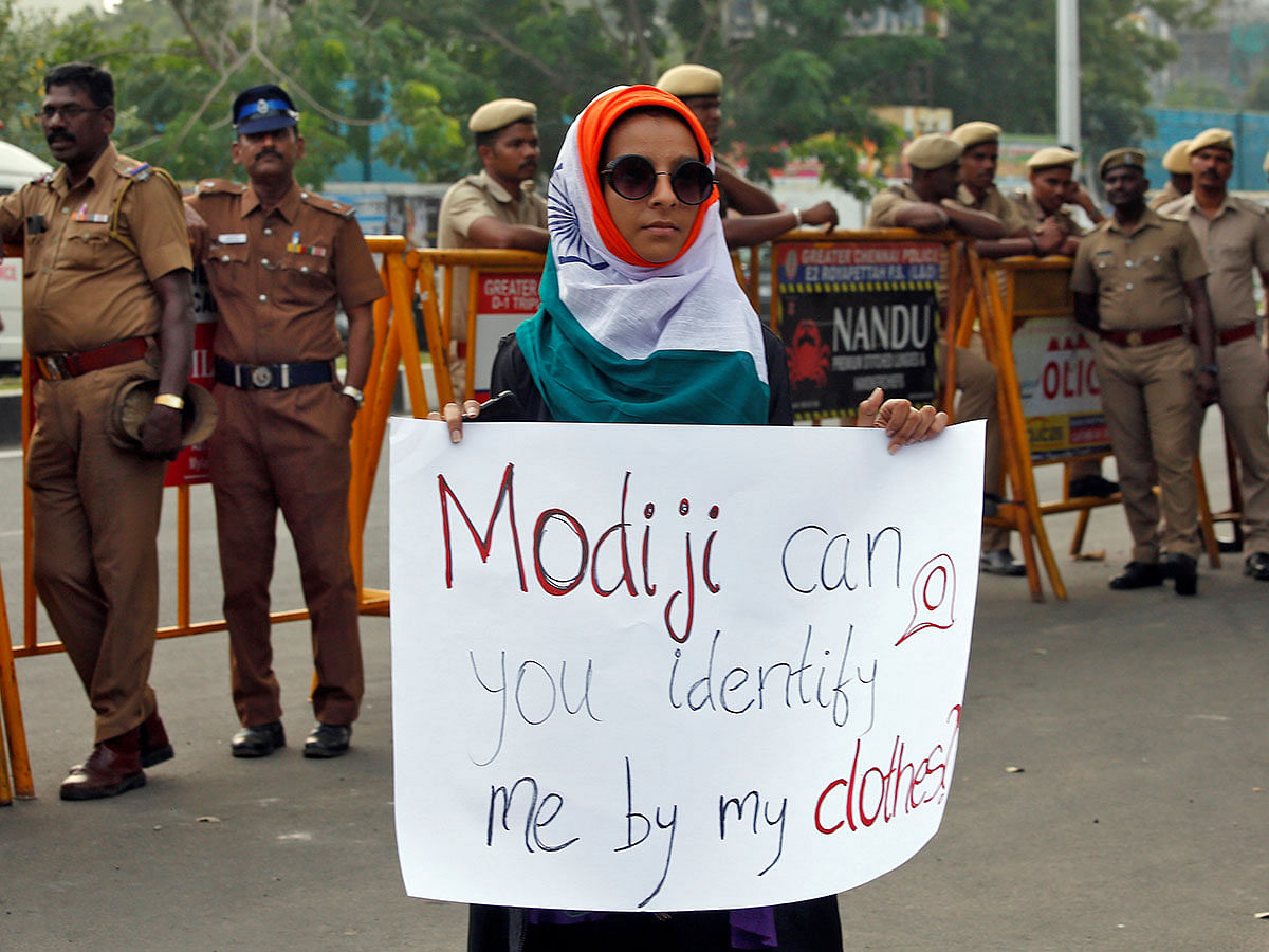 A demonstrator displays a placard as she attends a protest against a new citizenship law, in Chennai, India, on 20 December 2019. Photo: Reuters