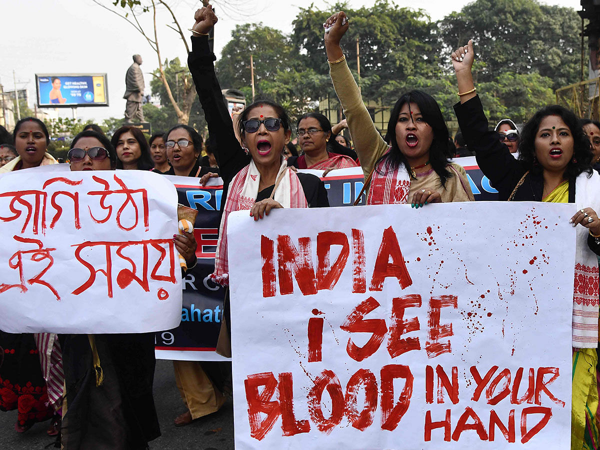 Female demonstrators hold placards and shout slogans during a protest against India`s new citizenship law in Guwahati on 21 December 2019. Photo: AFP