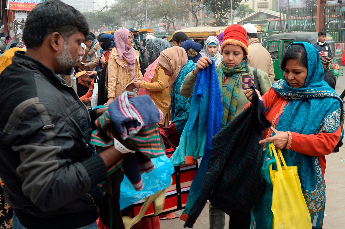 People browse through street vendors` stalls selling winter clothes in Dhaka on 21 December 2019. Photo: AFP