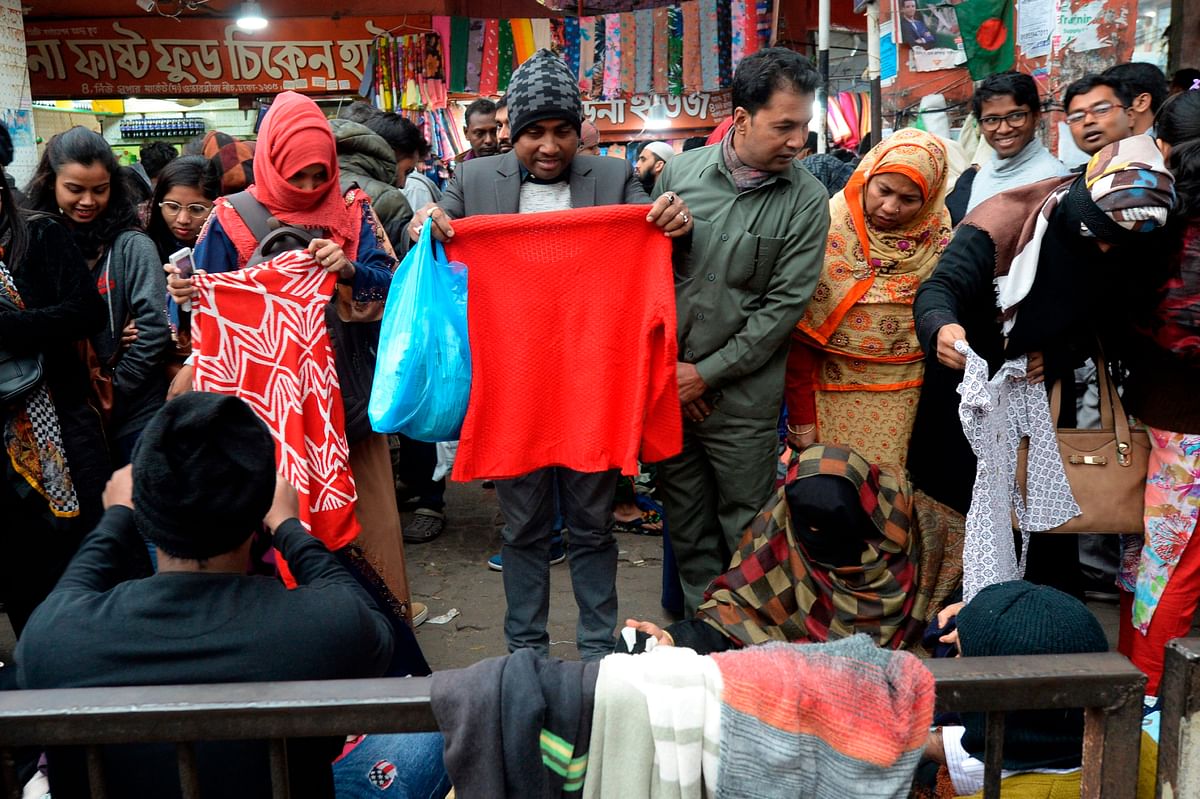 People browse through street vendors` stalls selling winter clothes in Dhaka on 21 December 2019. Photo: AFP