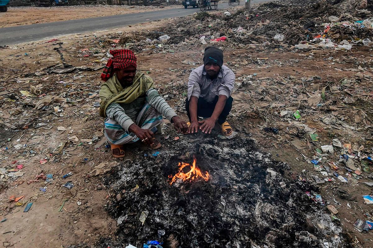 Bangladeshi men warm themselves around a bonfire on a cold day in Dhaka on 19 December 2019. Photo: AFP
