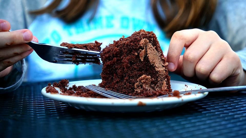 A woman eats cake. Photo: Pixabay