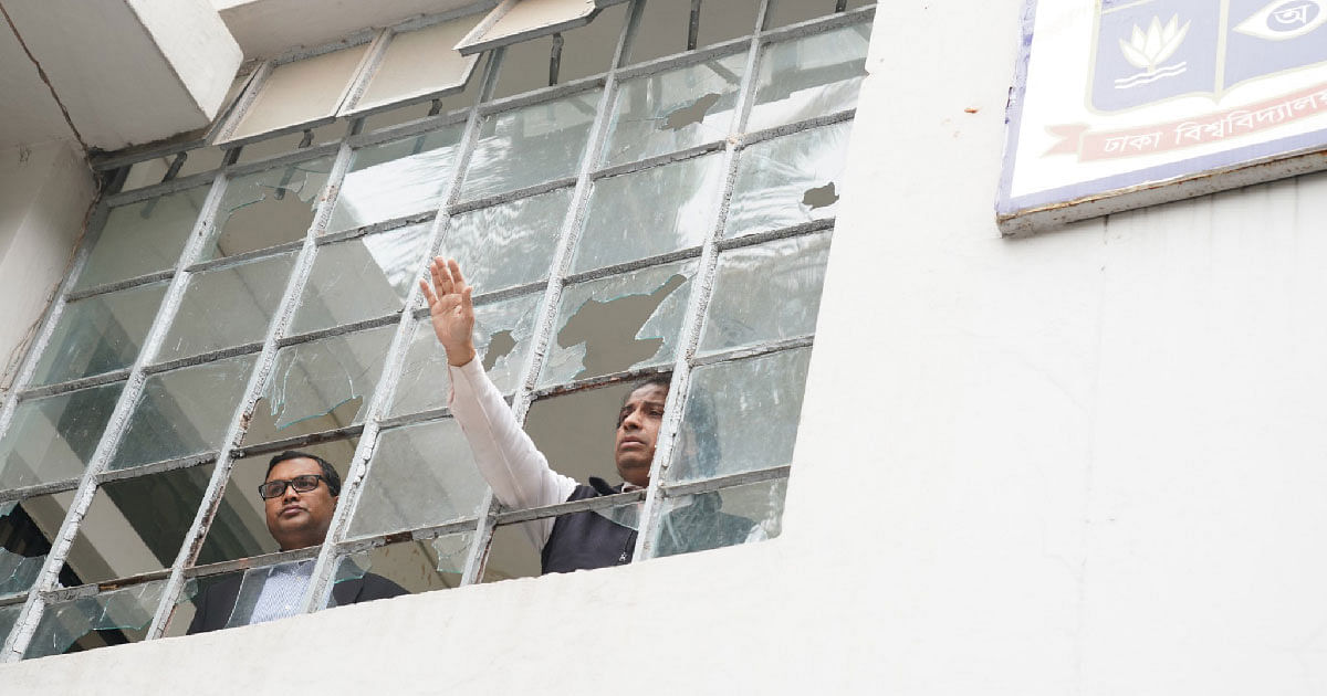 A man seeks help across a shattered window of a Dhaka University building. Photo: UNB