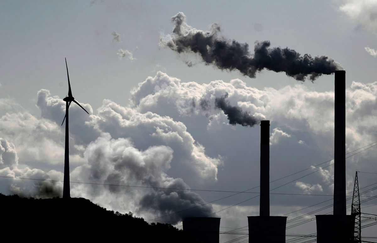 In this file photo taken on 02 October steam rises from a coal power plant of global energy supply company Uniper beside a wind turbine in Gelsenkirchen, western Germany. Photo: AFP