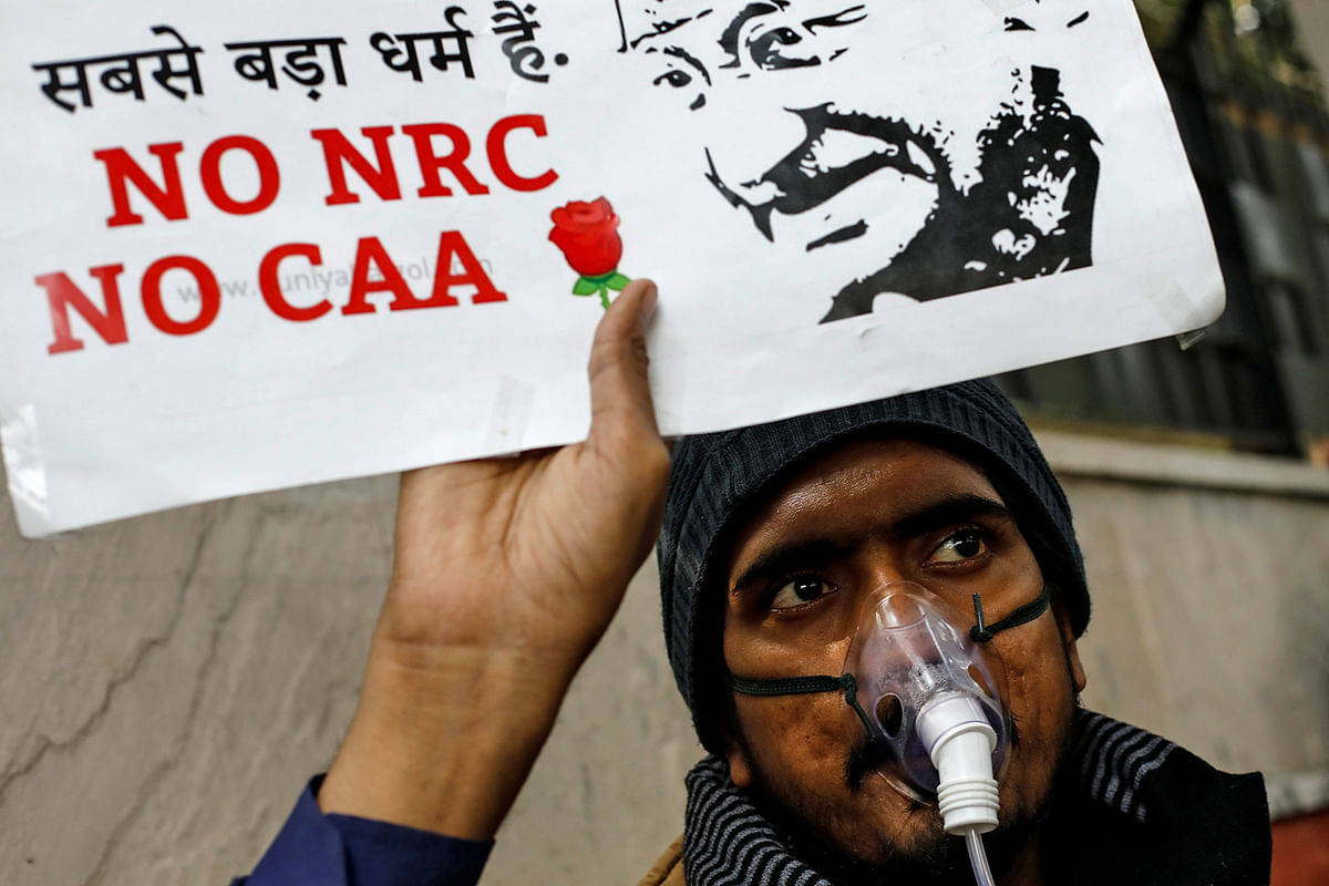 A demonstrator holds a placard during a protest against a new citizenship law, in New Delhi, India, on 24 December 2019. Photo: Reuters