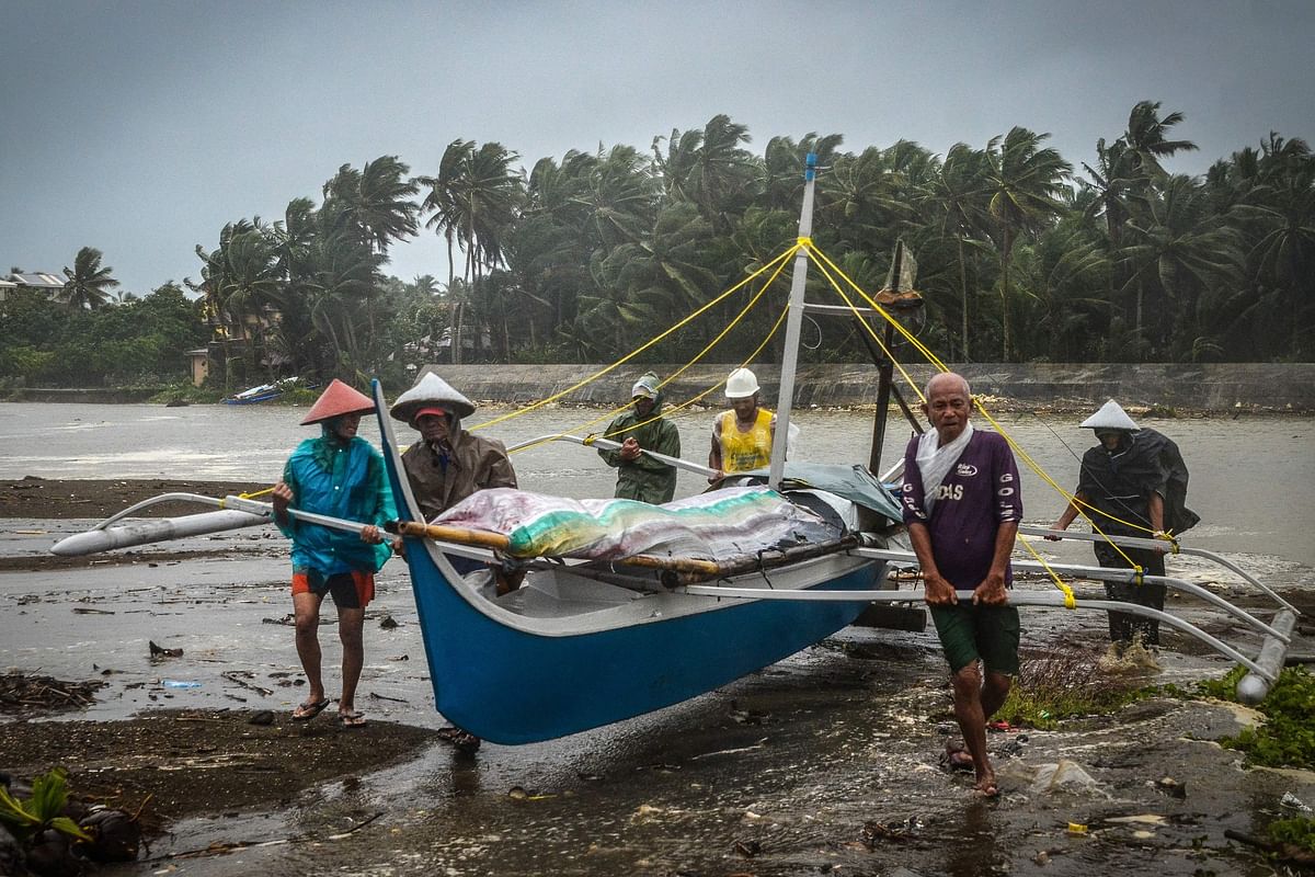 Fishermen carry a boat to higher ground in Baybay, eastern Samar on 24 December 2019, after typhoon Phanfone hit the central Philippines. Photo: AFP