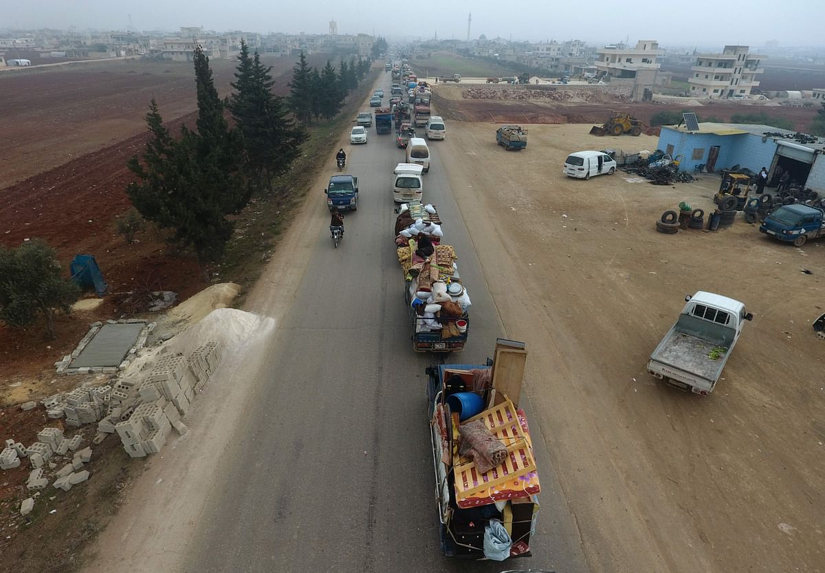 This aerial view taken on 24 December 2019, in the village of Hazano, about 20 kilometres northwest of the city of Idlib, shows Syrian families from the south of Idlib province driving through the town towards the Syrian-Turkish border as they flee from the assault led by government forces and their allies. Photo: AFP