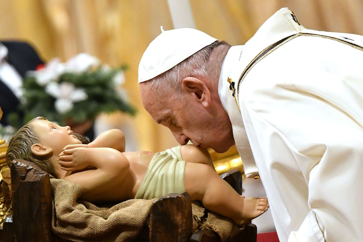 Pope Francis kisses a figurine of baby Jesus during a mass on Christmas eve on 24 December 2019, at St Peter`s basilica in the Vatican. Photo: AFP