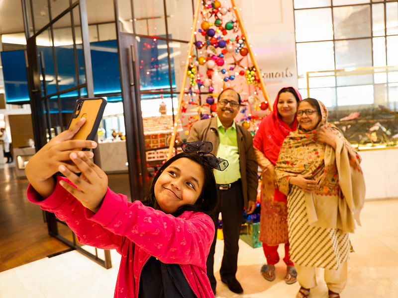 A child takes a selfie with her family during a visit to a church ahead of Christmas in Dhaka on 24 December 2019. Photo: Dipu Malakar