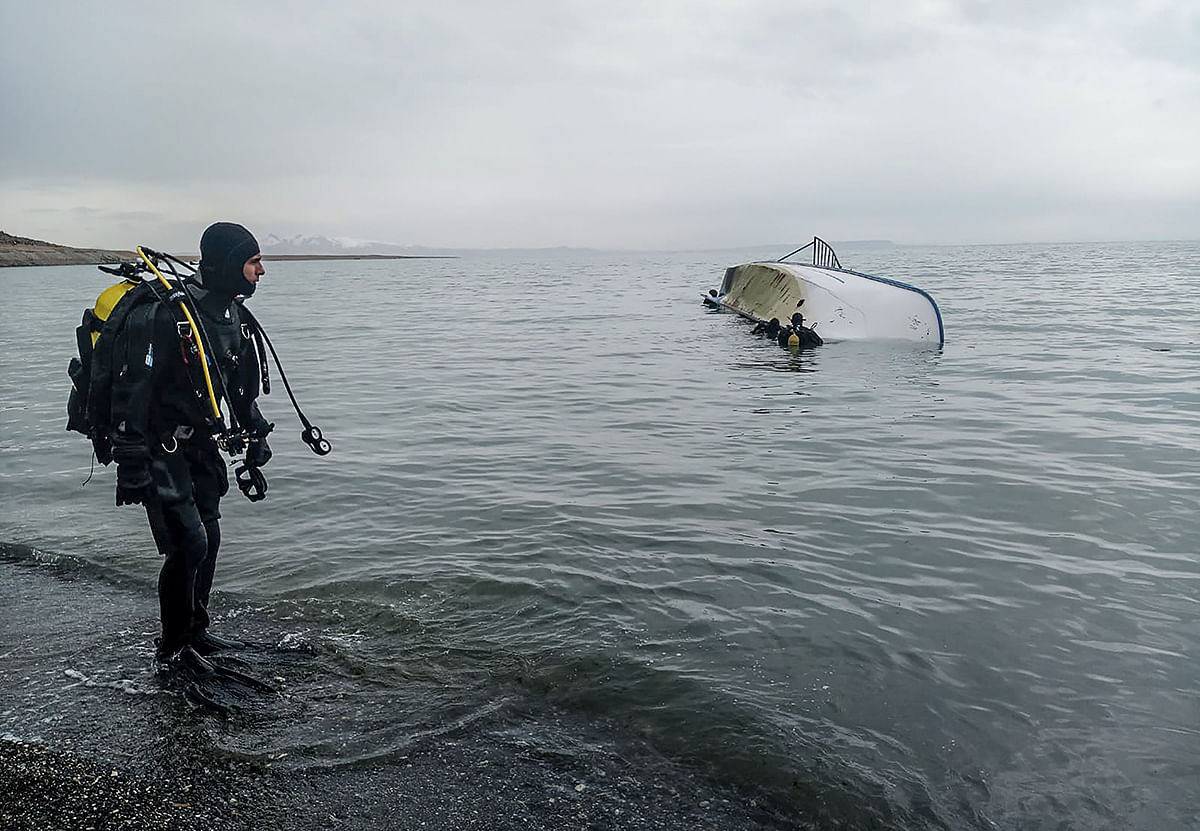 A handout image made available by the Demiroren news Agency on 26 December, 2019, shows a rescue diver standing on the shores of Lake Van after a boat carrying refugees and migrants sank in eastern Turkey. Photo: AFP