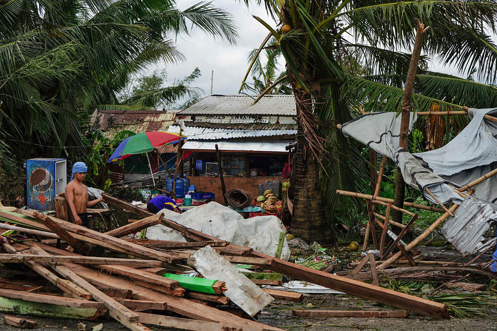 A resident looks at a house damaged at the height of Typhoon Phanfone in Tacloban, Leyte province in the central Philippines on 25 December 2019. Photo: AFP